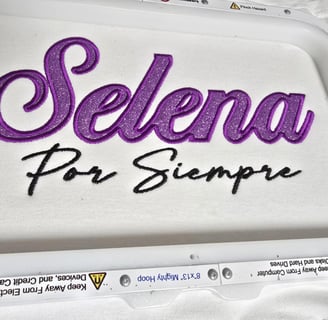 Selena Por Siempre embroidery in glittered purple and black script on white fabric – San Antonio