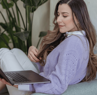 a young freelancer sitting on a couch with a laptop