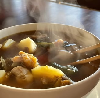 a bowl of bouillon soup with chopsticks and chopsticks