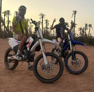 Moto cross 125 et 250 cc dans le désert marocain proche d'une palmerais