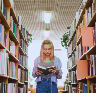 a woman is standing in a library with a bookcase