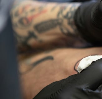 Tatuador desenvolvendo sua arte no braço de um cliente