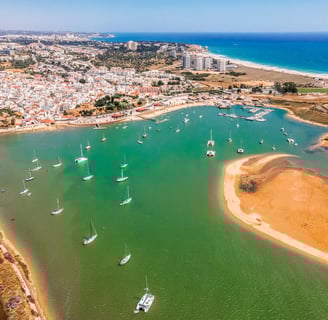 Aerial view of Alvor’s tranquil lagoon with the village and the ocean in the backgr