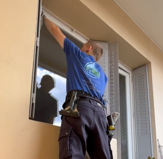 Une personne qui nettoie les encadrements d'une vitre