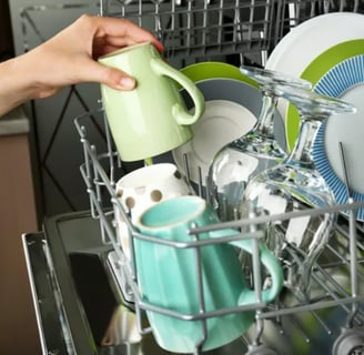 Plates, cups and glasses inside a dishwasher basket
