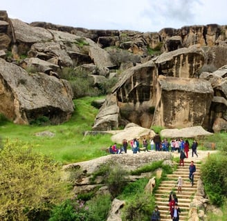 a group of people walking up stairs in a rocky area