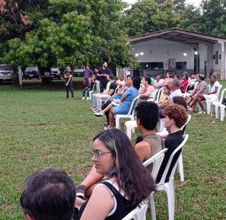 Cenário do recital com árvores frutíferas ao fundo.