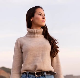 a woman in a turtle neck sweater and jeans