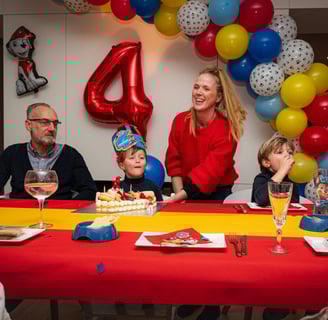 a family celebrating a birthday party with a birthday cake