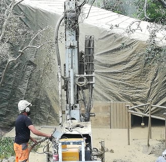 On y voit un technicien, Foreuse en pleine action pour un forage de qualité sur terrain difficile.