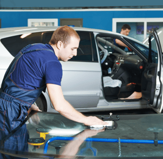 a man in a blue shirt is cleaning a car