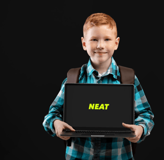 a boy holding a laptop computer with a sign that says neat