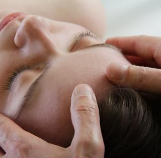 een vrouw krijgt een manuele behandeling aan haar hoofd
