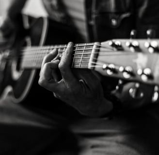 gros plan sur les mains d'un homme jouant de la guitare acoustique