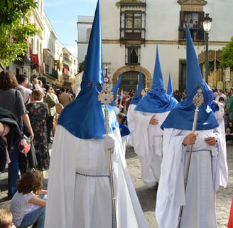People in Blue and Red Robes Walking on the Street of Seville on Semana Santa