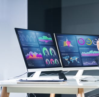 a man sitting at a desk with two monitors and a laptop-digital marketing institution