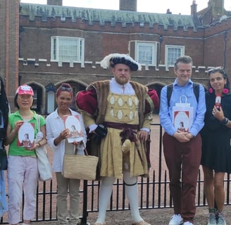 a group of people standing in front of St James's Palace with Henry VIII