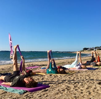 a group of people doing yoga on a beach