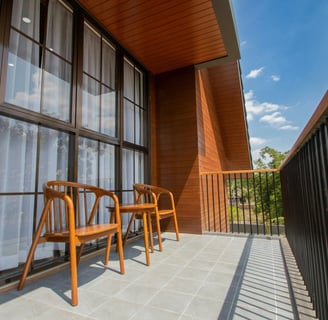 a balcony with chairs and a table with chairs