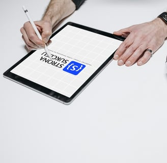 a man is writing on a tablet with a pen and headphones