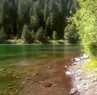 Eugene, OR - The emerald glass lake is pure tranquility at the bottom of Sahalie Falls loop trail