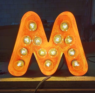A neon sign with a letter m