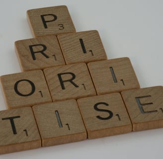 a pyramid shaped wooden block with the word prioritise