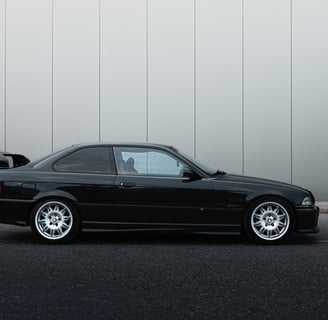 a black bmw m3 e36 parked in front of a building