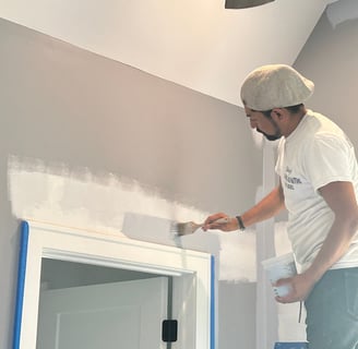 a man is painting a wall with a paint roller