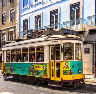 a trolley car with people walking down the street in Lisbon, Portugal