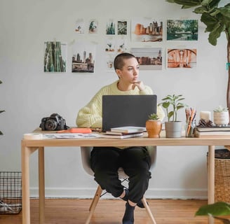 a woman sitting at a desk with a laptop computer