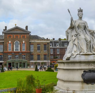 Kensington Palace exterior with a statue of a woman in a dress and a crown