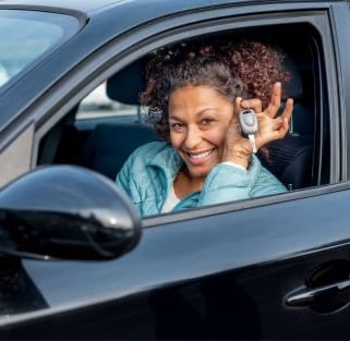 a woman in a car holding up her keys