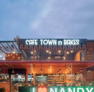 a cafe and bakery with a neon sign that says nandyala