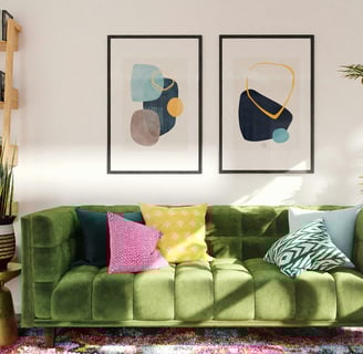 a green couch with colorful pillows and a potted plant
