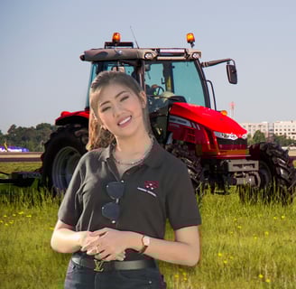 a woman in a black shirt and jeans standing in front of a tractor