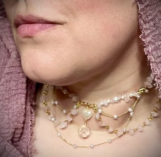 a woman in pink hijab wearing a delicate multi-chain necklace with rose quartz and pearl beads