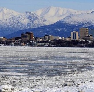 Anchorage, AK - A view of the city of Anchorage in winter with mountains in the background