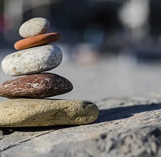 Foto de pedras empilhadas alinhadas representando equilíbrio atingido no consultório de psicologia.
