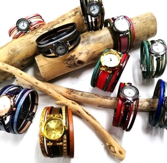 a bunch of bracelets and watches on a stick