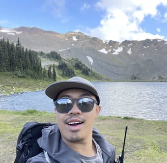 a man with sunglasses and a backpack on a mountain