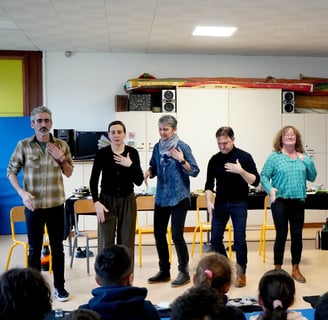 un groupe de musiciens fait des percussions corporelles devant des enfants dans une école