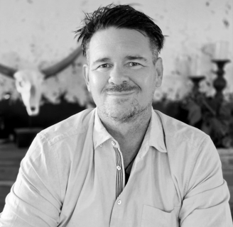 Photo of Mike in black and white sitting at a table