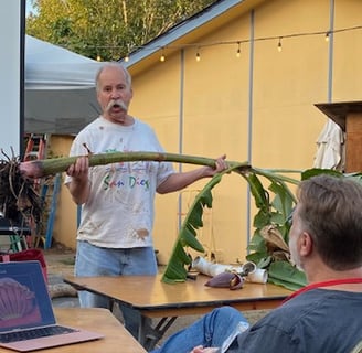 Jon Verdick holds a banana tree up for the audience