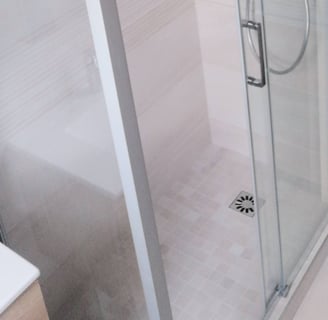 Douche avec porte coulissante et paroi fixe, carrelage beige clair