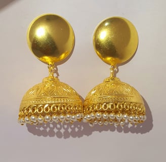 a pair of gold toned earrings with pearls and pearls