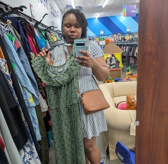 a woman standing in a store with a phone and a dress