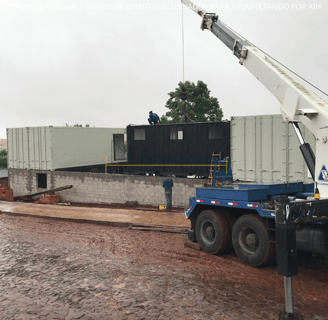 laboratório container sustentável, imagem da etapa construtiva,guincho colocando os containers