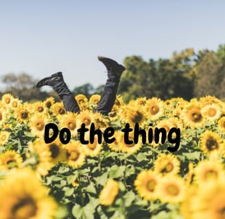 a person doing a handstand in a field of sunflowers