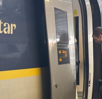 a group of people standing on a platform next to a train